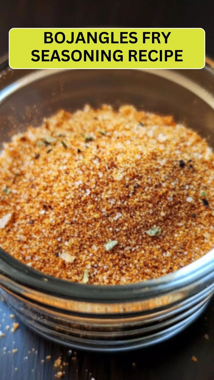 a glass bowl filled with seasoning on top of a wooden table