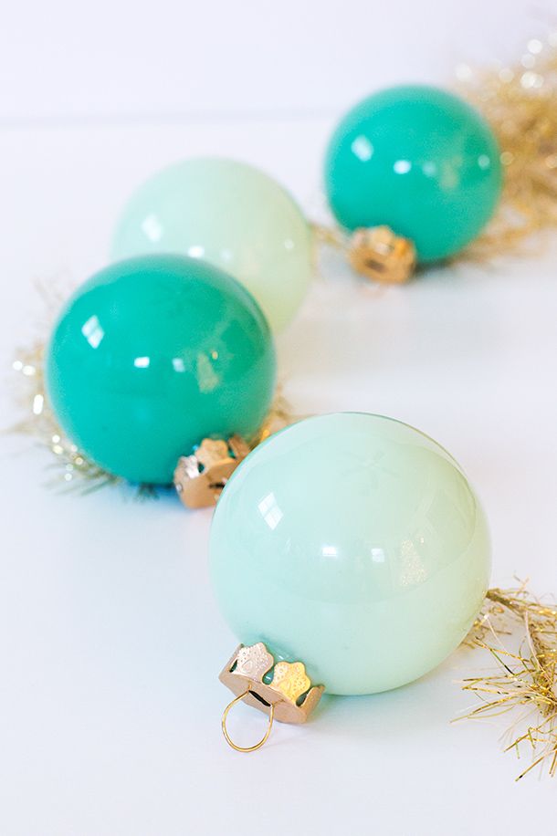 three green and white balloons with gold trimmings sitting on a table next to confetti