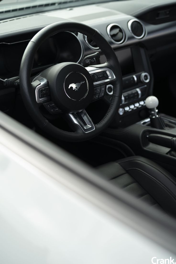 the interior of a car is shown with black trims and leather steering wheel covers