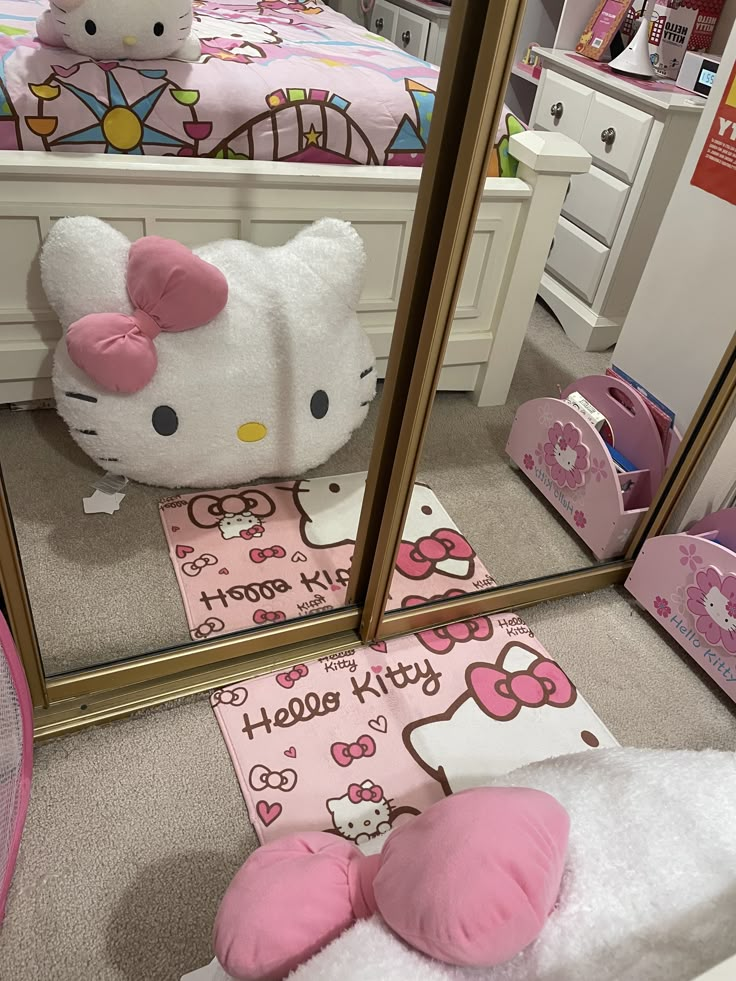 a hello kitty themed bedroom is shown in the mirror, with pink accessories on the floor