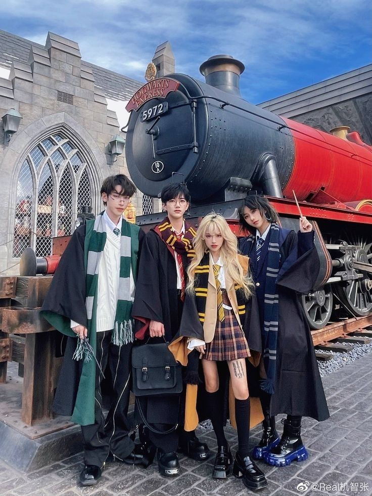 three people standing in front of a hogwarts express train at the wizard's studio