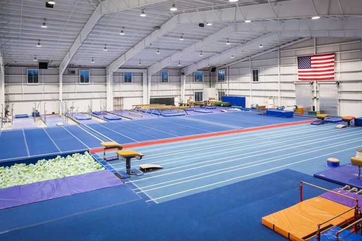 an empty gym with blue and yellow mats on the floor is shown in this image