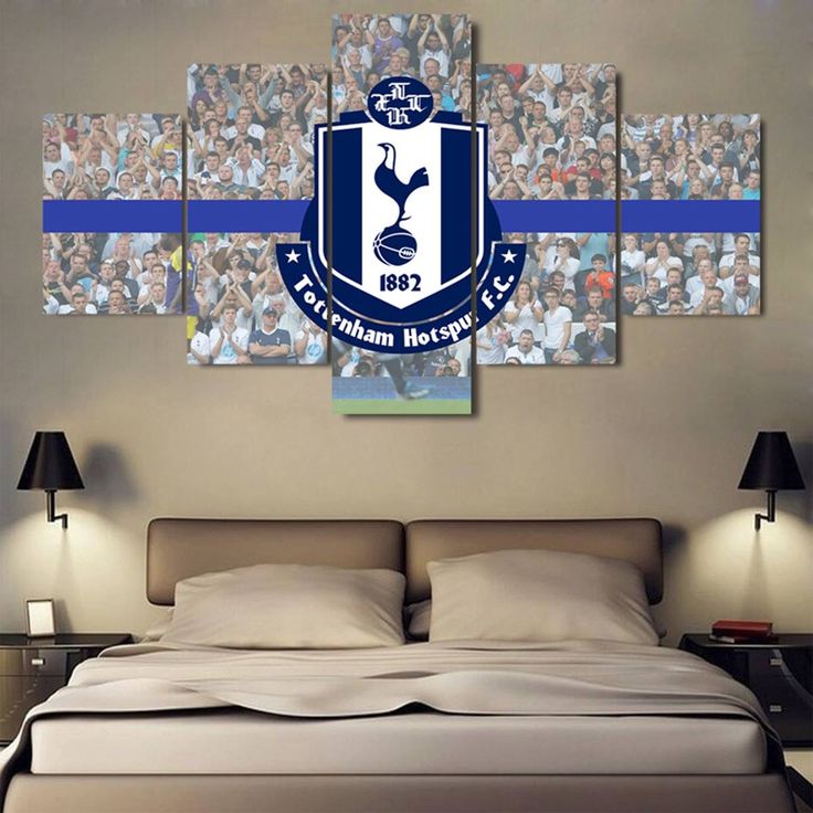 a bedroom with a large bed and pictures on the wall above it that says tottenham football club