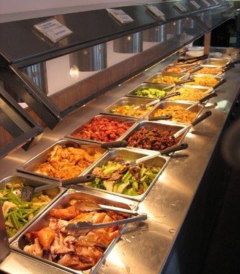 a buffet line with many different types of food on it's trays, including salads and sides