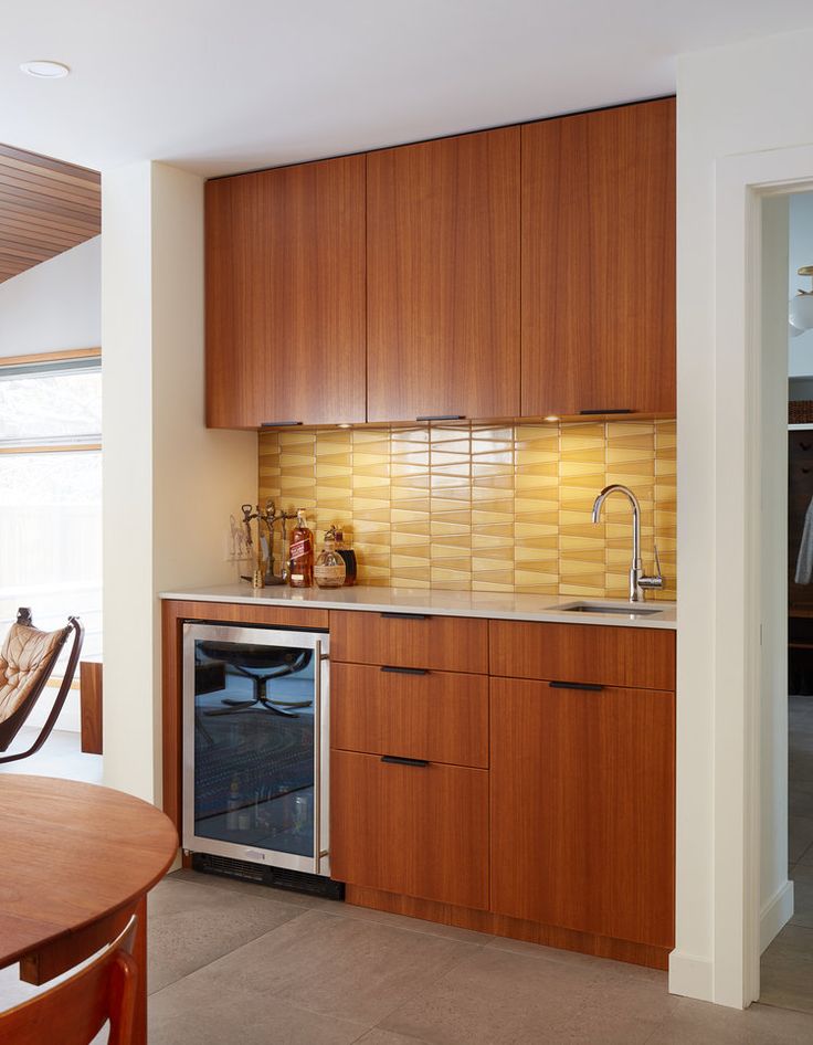 a kitchen with wooden cabinets and an oven in the center, next to a dining room table