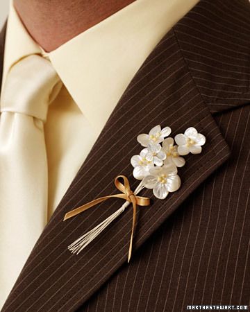 a man wearing a pinstripe suit and tie with flowers on the lapel