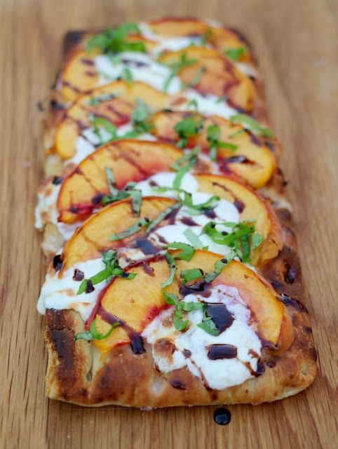 sliced peaches and black olives on top of flat bread