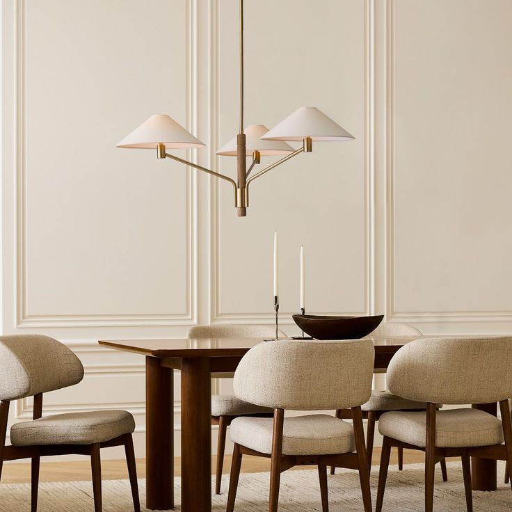 a dining room table with four chairs and a chandelier hanging from the ceiling