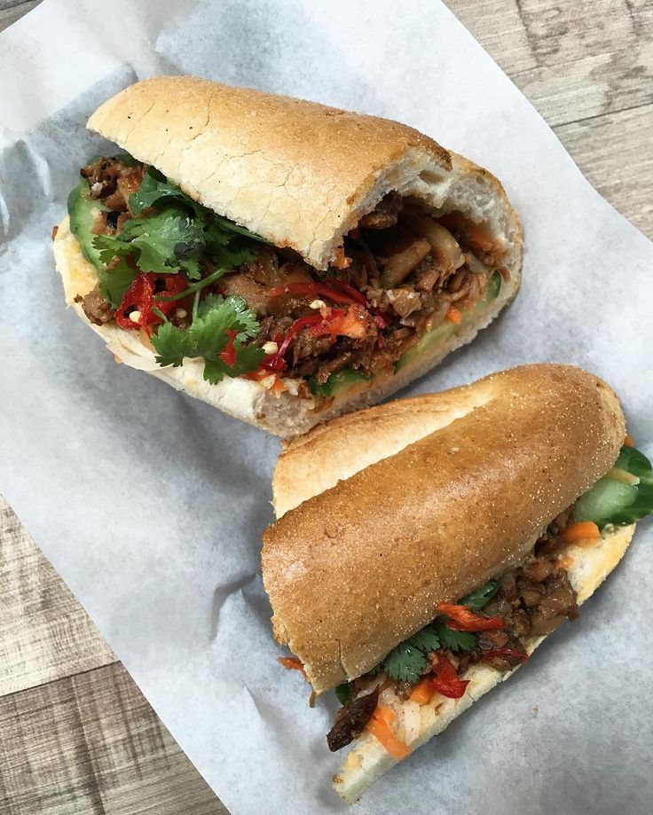 two sandwiches sitting on top of wax paper