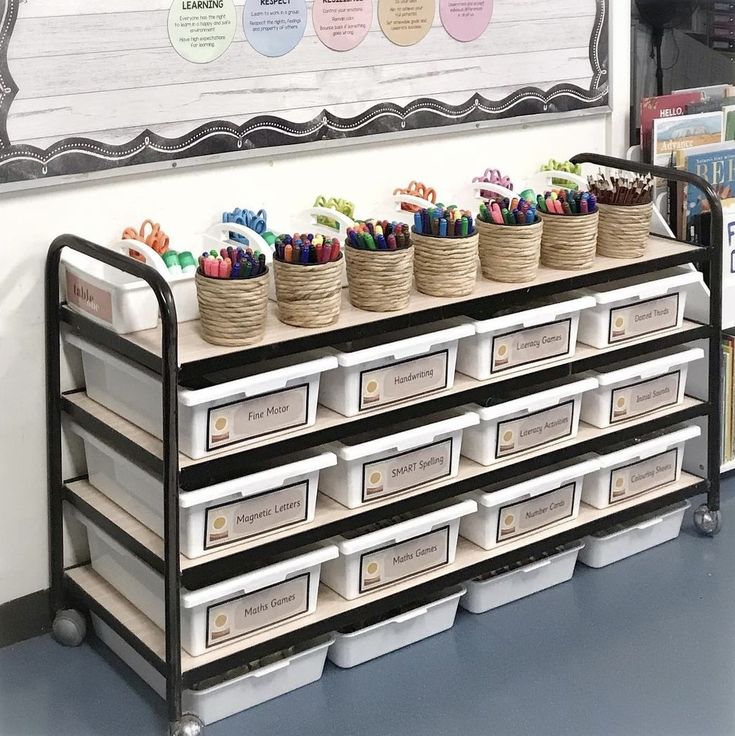 an organized classroom area with bins and baskets on the shelf for children's books