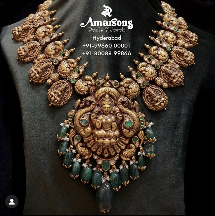 an elaborate necklace is displayed on a mannequin's neckline in gold and green