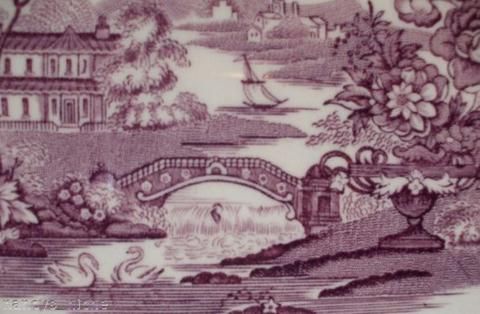 a plate with an image of a bridge and flowers on it