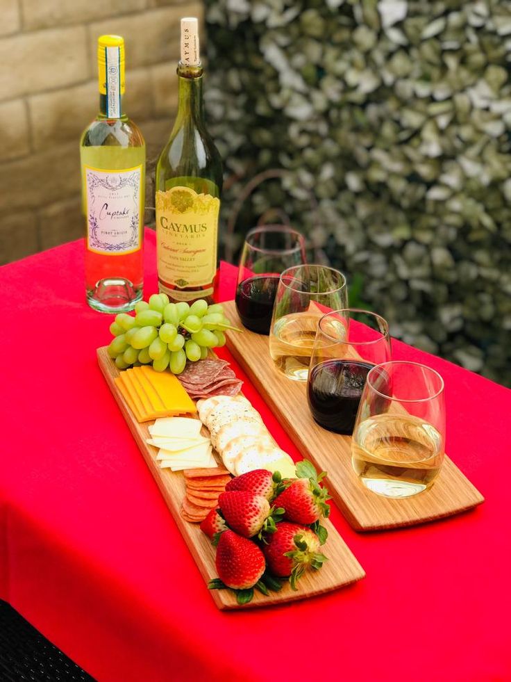 wine, cheese and strawberries are sitting on a table