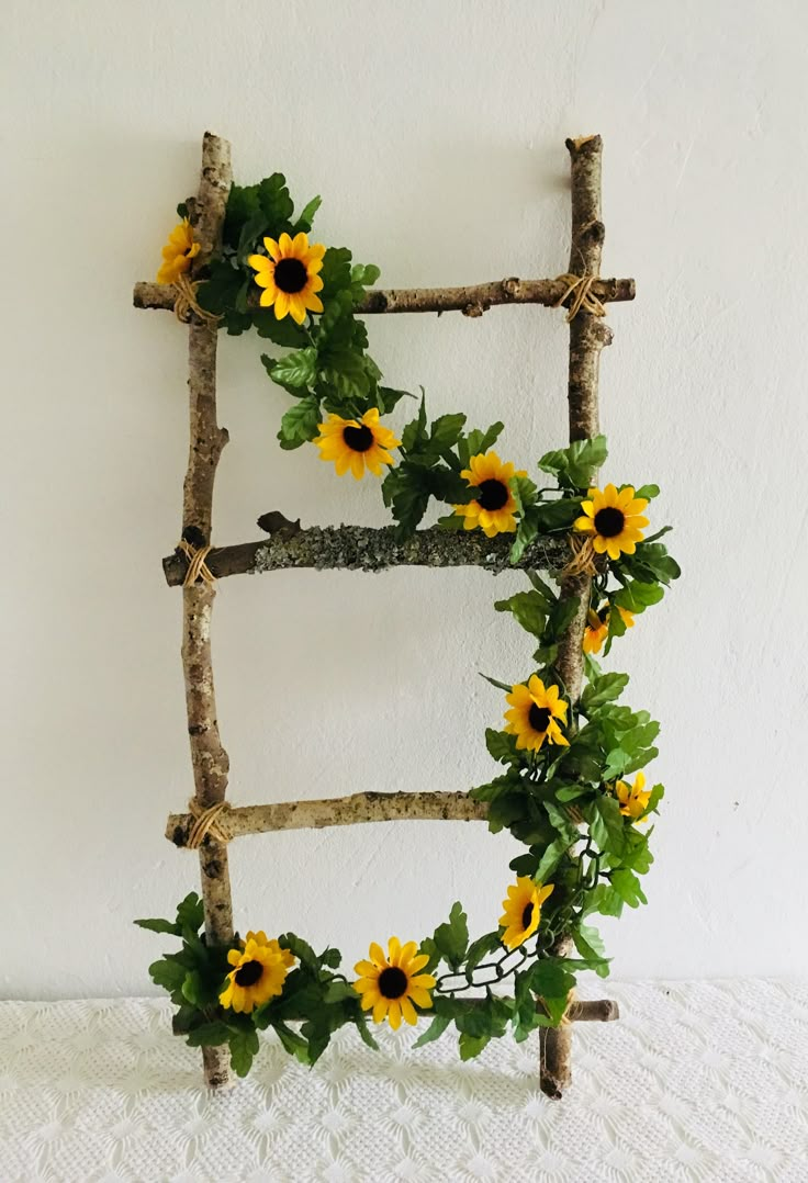 a ladder made out of branches with sunflowers on it