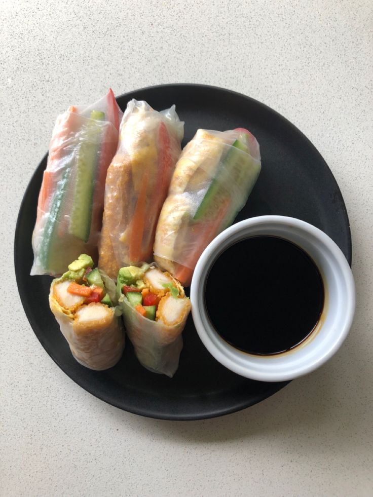 a black plate topped with rolls next to a cup of coffee