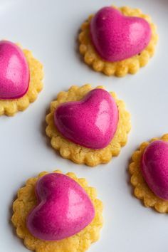 heart shaped cookies with pink icing on a white plate