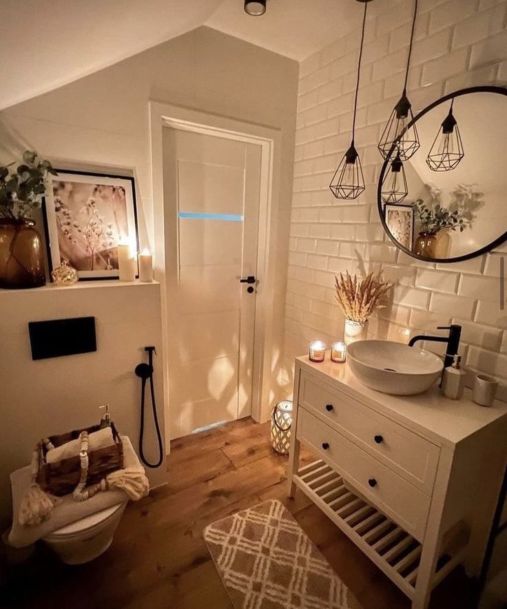 a bathroom with white brick walls and wooden flooring is lit up by candles on the side of the door