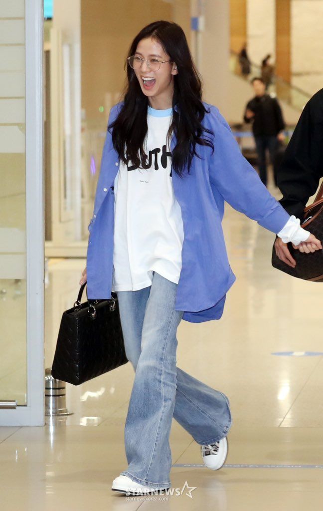 a young woman is walking through an airport