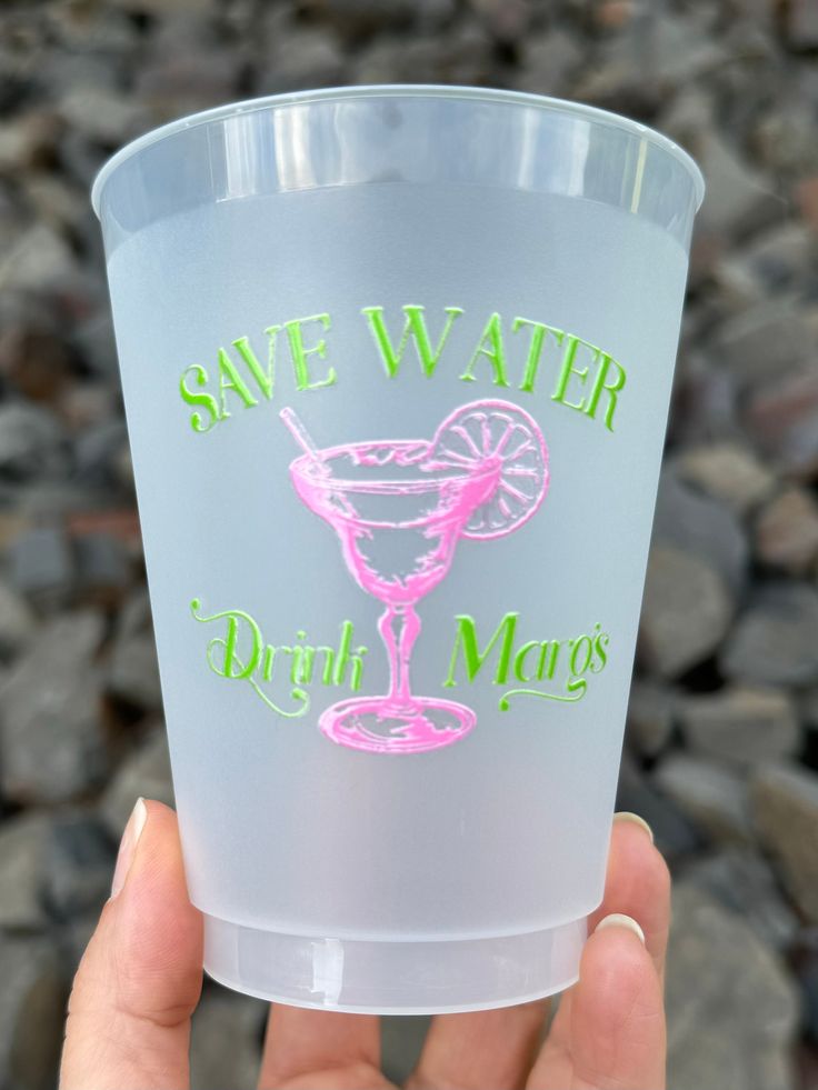 a hand holding up a plastic cup that says save water drink margarita