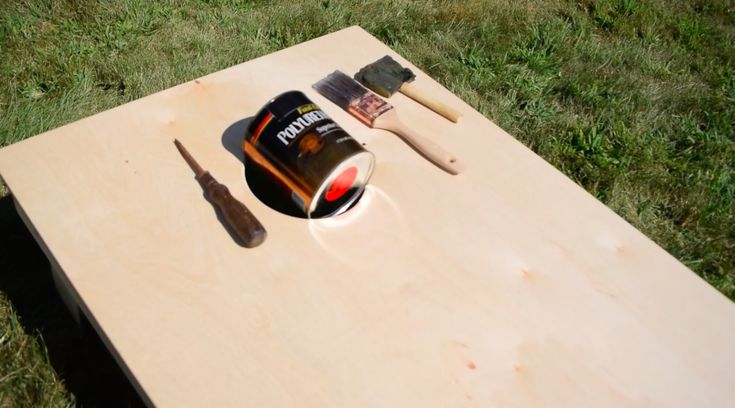 a wooden table with tools on it in the grass