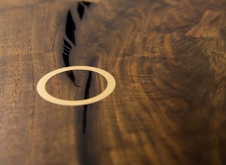 a close up of a wooden table with a ring on the edge and wood grained surface