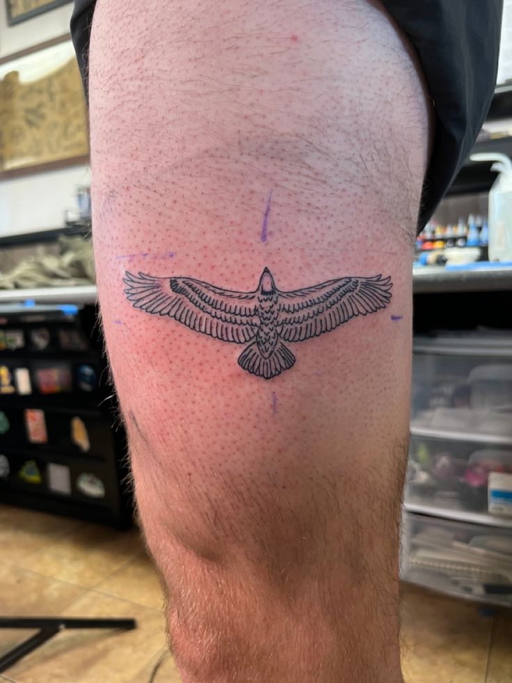 a man with a tattoo on his leg that has a bird drawn on the side