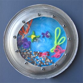 a metal bowl with an image of fish and seaweed in it on a blue background