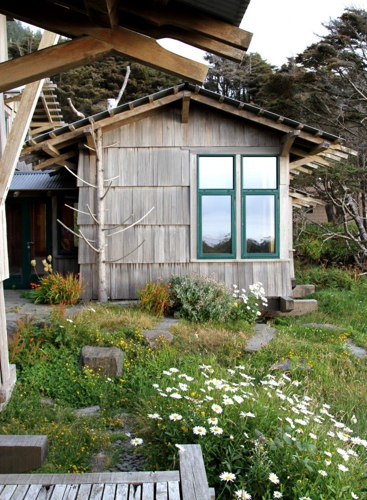 a small wooden house sitting on top of a lush green field