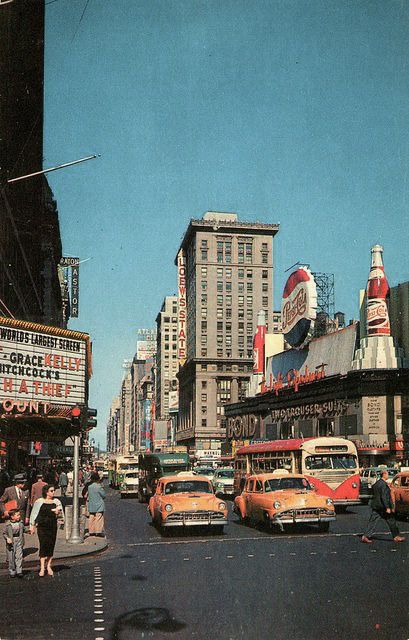 a busy city street filled with lots of traffic next to tall buildings and neon signs