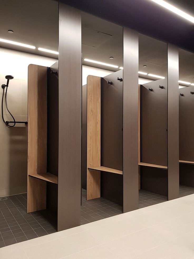 an empty public restroom with wooden stalls