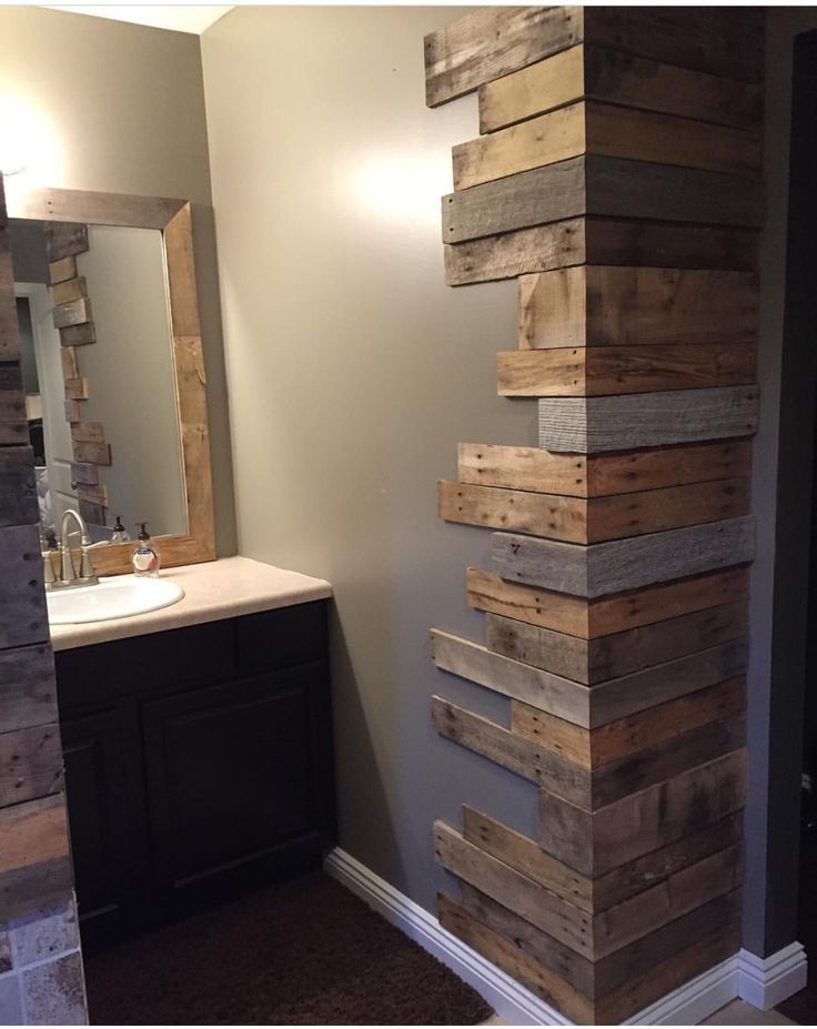 a bathroom with a sink, mirror and wooden planks on the wall in it