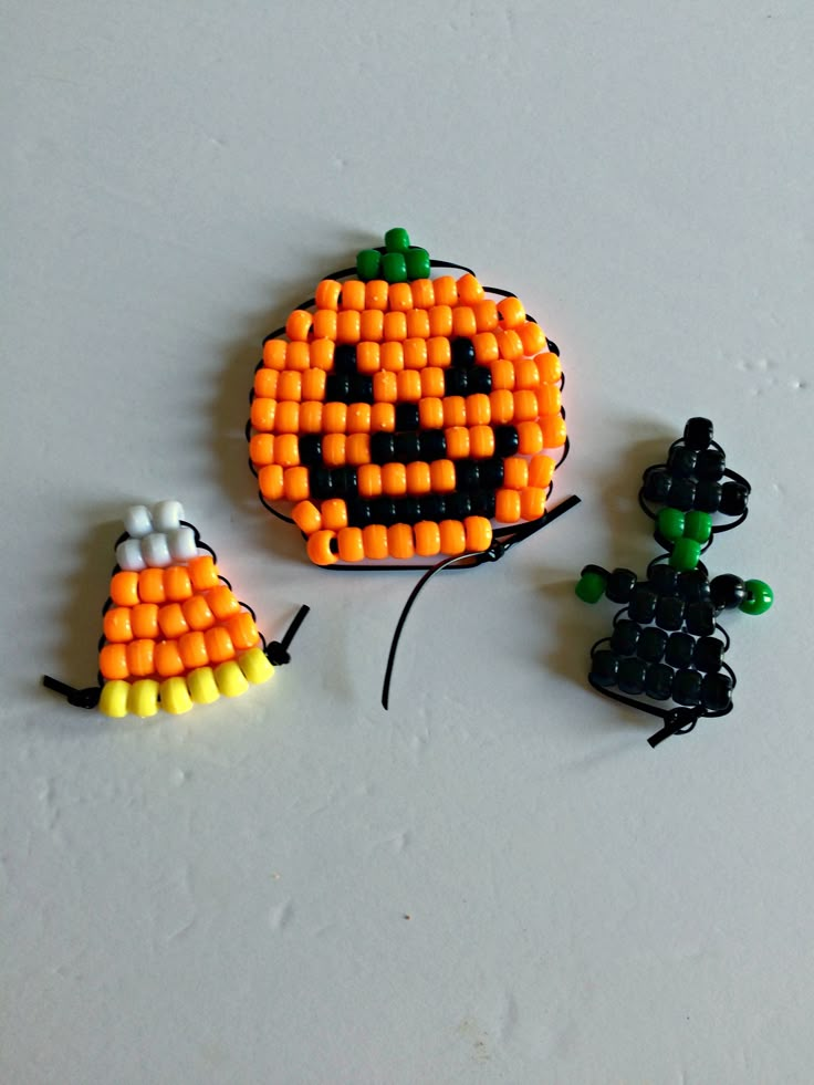 two pumpkins made out of beads sitting next to each other