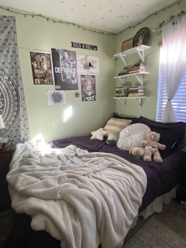 a bedroom with green walls and pictures on the wall above the bed, along with stuffed animals