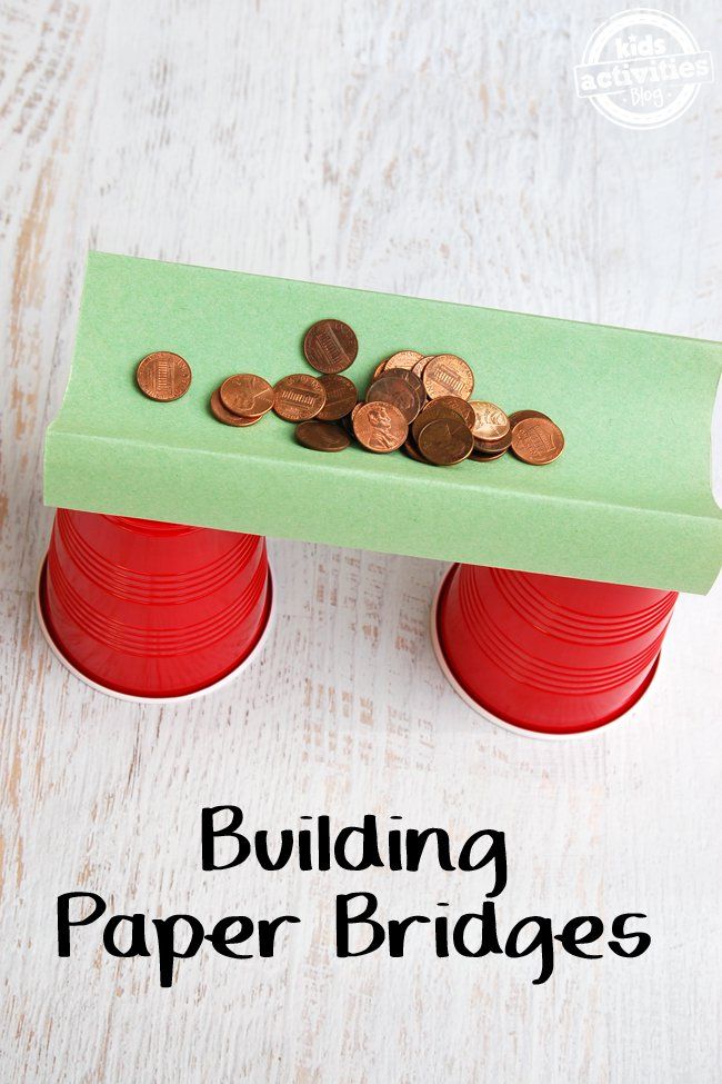 some coins are sitting on top of a red cup with a green paper over it