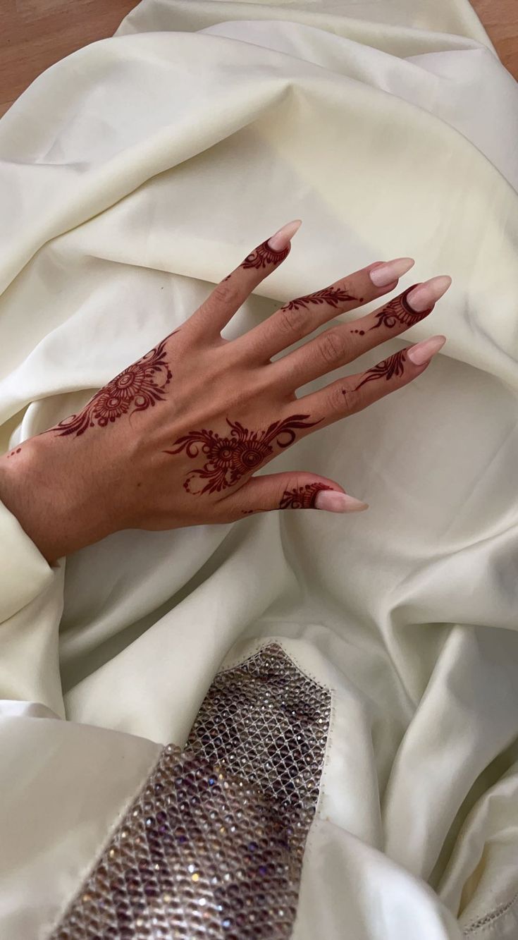 a woman's hand with hendix on it laying on a white cloth