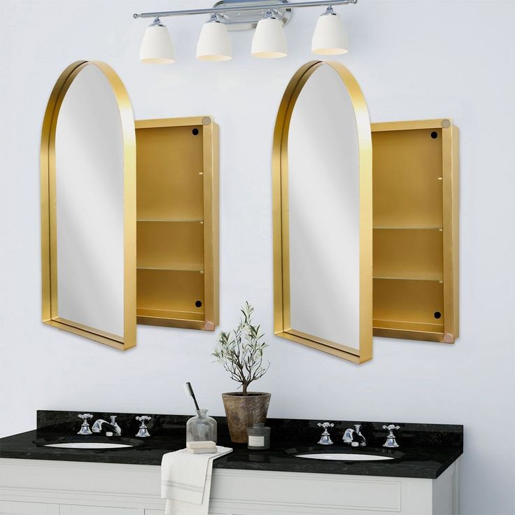 there are two mirrors on the wall above the sinks and one is gold in color