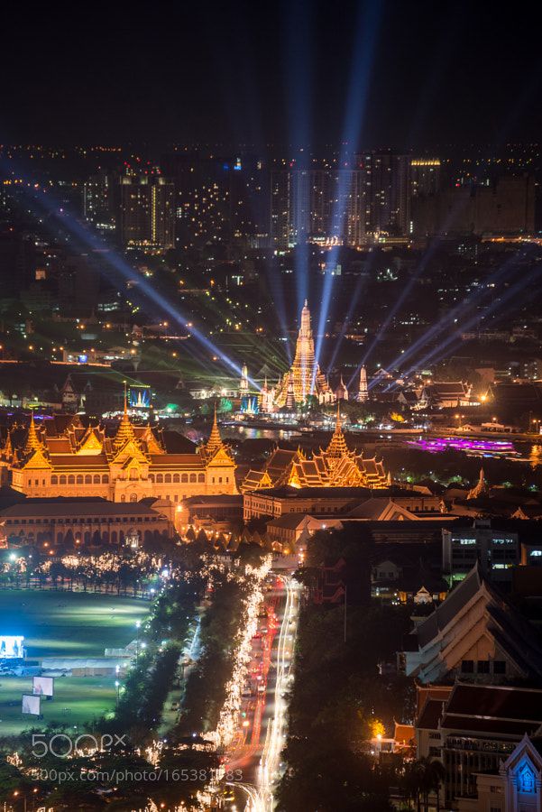 an aerial view of a city at night with bright lights and buildings in the background