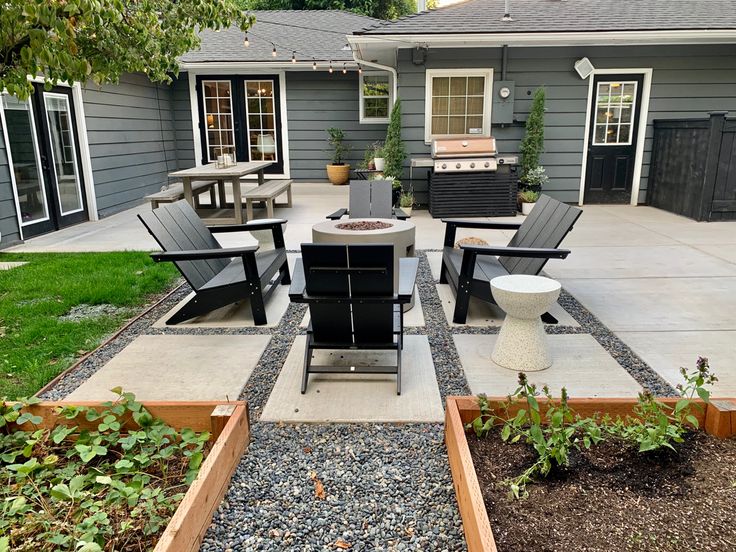 an outdoor patio with chairs, table and grill