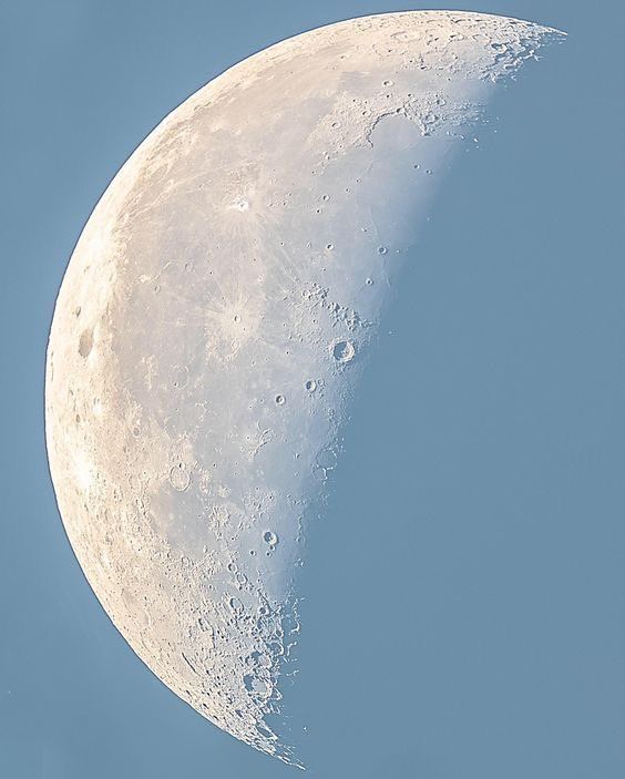 the moon is in the blue sky and it appears to be half - mooned