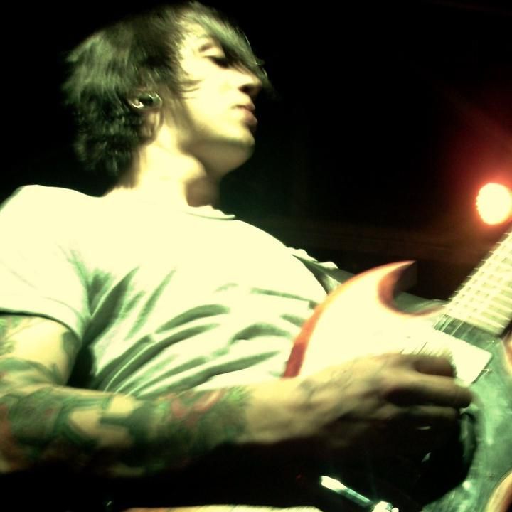 a man with tattoos playing an electric guitar