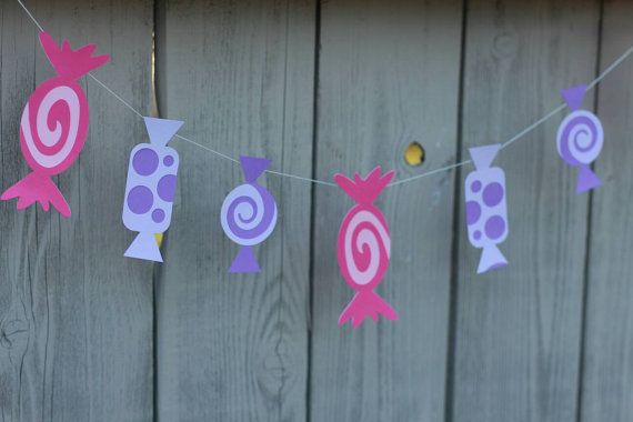 some pink and purple decorations hanging from a line