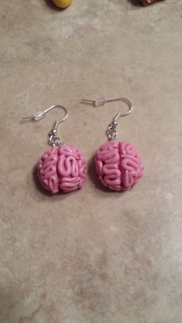 two pink earrings sitting on top of a counter