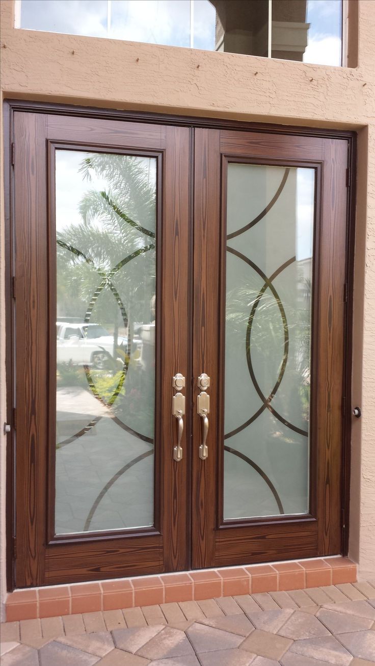 two double doors with glass on each side and brick walkway in front of the door