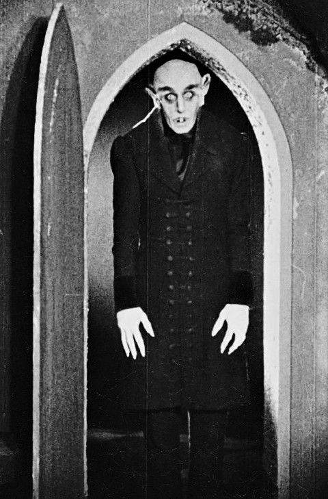 an old photo of a man dressed in dracula costume