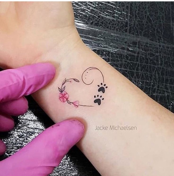 a person with a small tattoo on their left arm and paw prints on the wrist