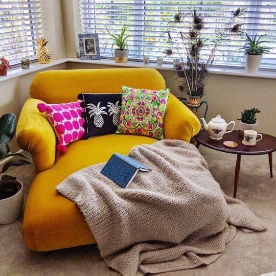 a living room with a couch, coffee table and potted plants