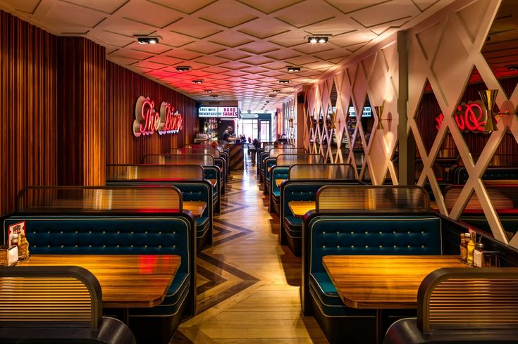 the interior of a restaurant with wooden tables and booths