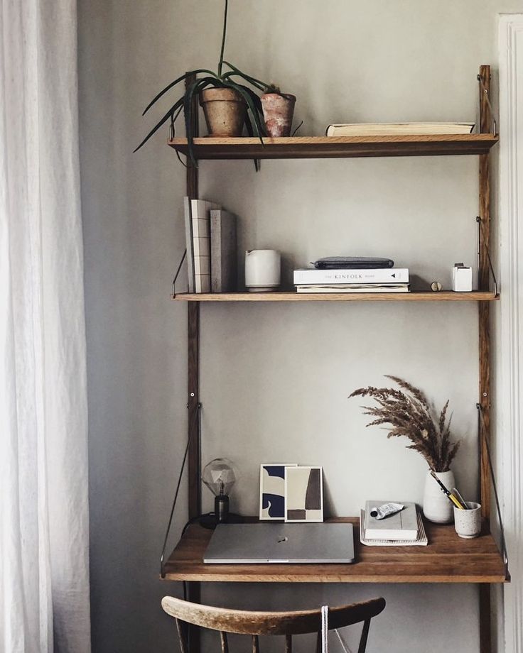 a desk with a laptop and some plants on it