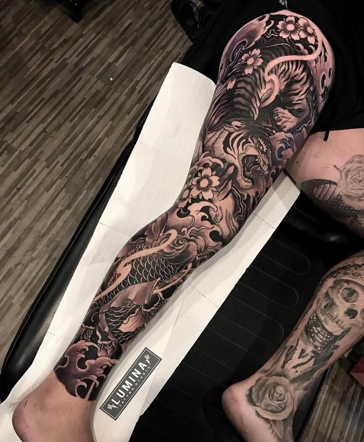 a man's leg with tattoos on it