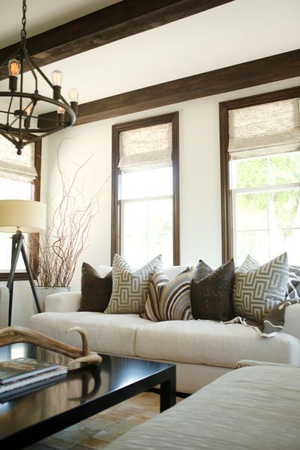 a living room filled with lots of furniture next to two windows and a coffee table